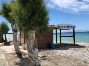 a sign on a beach next to two trees at Retas apartment in Kremasti +8 photos