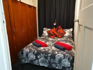 a bedroom with a bed with red and blue pillows at Meyenburg Units in Mount Morgan