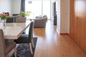 uma sala de estar com uma mesa e uma sala de estar com um sofá em Alto das Marinhas em Aveiro