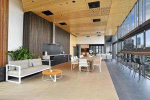 - un hall d'un immeuble avec des tables et des chaises dans l'établissement Brisbane One Apartments by CLLIX, à Brisbane