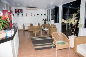 a living room with chairs and a table and a dining room at Hotel Morada do Mar in Guarujá