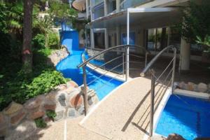 - une piscine d'eau bleue à côté d'un bâtiment dans l'établissement Cap Salou Zeus, à Salou