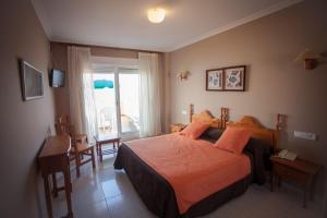 a hotel room with a bed and a window at Hotel Martín Esperanza in Portonovo