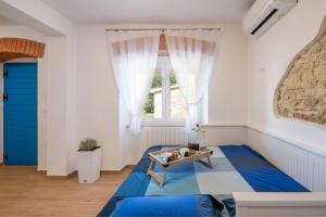 a bedroom with a blue bed and a window at Studio Q in Fažana