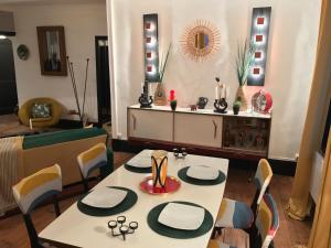 een eetkamer met een tafel en stoelen en een tafel en een spiegel bij LA RIEUSE POUET-POUET in Mers-les-Bains