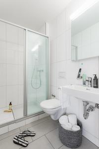 uma casa de banho com um chuveiro, um WC e um lavatório. em Swiss Star Marc Aurel - Self Check-In em Zürich