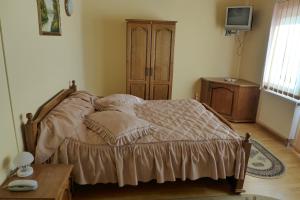 a bedroom with a bed with pillows and a table at Pensiunea Ana Maria in Brad