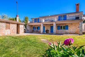 a large stone house with a lawn in front of it at Studio Q in Fažana