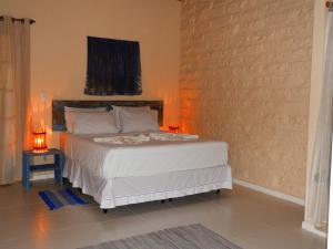 a bedroom with a bed and a brick wall at Pousada Pedras de Igatu in Igatu
