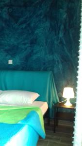- une chambre avec un lit et une table avec une lampe dans l'établissement KOSTAS FAMILY ROOMS, à Stavros