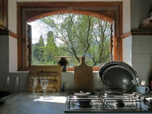 a kitchen with a stove and an open window at Space in Paradise in Castelbuono
