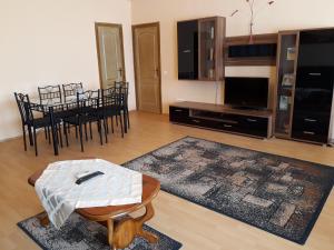 a living room with a table and a tv and a table and chairs at Piac utcai Apartman in Debrecen