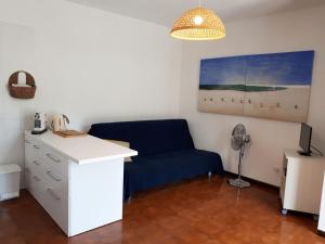Cette chambre dispose d'un canapé bleu et d'un bureau. dans l'établissement Nisportino, à Rio nellʼElba