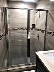a shower with a glass door in a bathroom at Central Inn Motel in Los Angeles