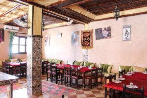 um restaurante com mesas e cadeiras num quarto em La Rose De Sable em Aït-Ben-Haddou