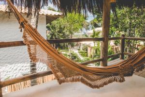 a hammock on a porch of a house at Hotel Boutique Bahia Bonita in Trancoso