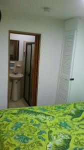 um quarto com uma cama e uma casa de banho com um lavatório em Habita Estudios Laureles em Medellín