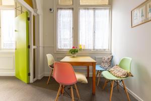 a room with a table and chairs and windows at BK Hostel in Auckland