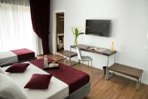 a hotel room with two beds and a desk at Unicum Roma Suites in Rome