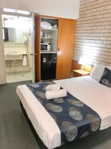 
a hotel room with a bed and a desk at ZED MOTELS Tropical Gateway in Rockhampton
