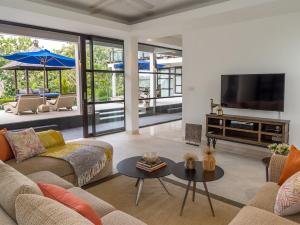 sala de estar con 2 sofás y TV en Villa Adenium by Elite Havens, en Jimbaran