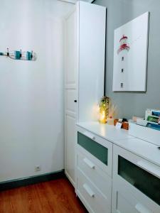 kuchnia z białą szafką z oświetleniem w obiekcie Happy Home Getxo Beach w mieście Getxo