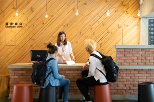 three women sitting at a counter talking to a woman at MEANDER Taipei in Taipei