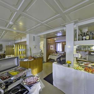 a kitchen with a buffet of food in a restaurant at Hotel Sporting in St. Gallen