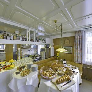 - une cuisine avec 2 tables et de la nourriture dans l'établissement Hotel Sporting, à Saint-Gall