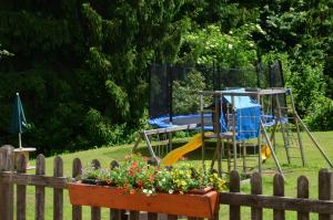 um jardim com um parque infantil e um baloiço em Residence Bonetei em Dimaro