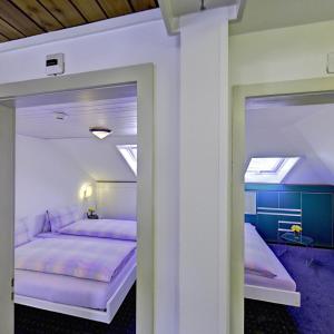 a bedroom with two beds with purple sheets at Hotel Sporting in St. Gallen