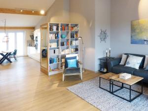 a living room with a couch and a book shelf at Weiße Düne Ferienwohnung *Weiße Düne 7* in Wittdün
