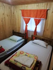A bed or beds in a room at Cabañas El Toro - Radal Siete Tazas