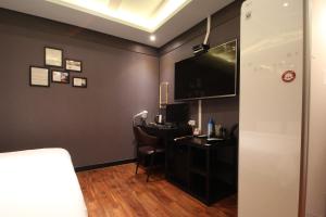 a room with a desk and a tv on the wall at French code Hotel in Changwon