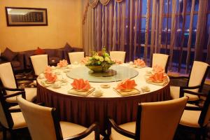 a round table with chairs and a vase of flowers at University Town International Hotel in Guangzhou