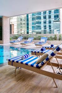 a row of lounge chairs next to a swimming pool at The Sphere Serviced Residences Managed by HII in Manila