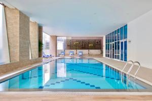 a large pool with blue water in a building at The Sphere Serviced Residences Managed by HII in Manila