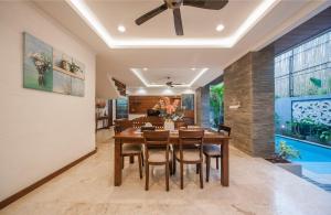 a dining room with a table and chairs and a ceiling fan at Villa Suzuki 1 Seminyak in Seminyak