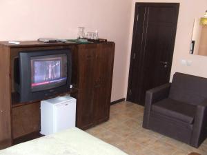 a living room with a tv and a chair at Varnaflats Guest Rooms in Varna City