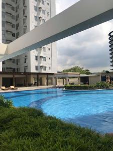 une grande piscine en face d'un bâtiment dans l'établissement Cozy 922 at Tower One, à Cebu
