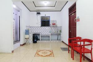 sala de estar con chimenea y sillas rojas en Arjuna Hostel, en Semarang