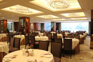 a banquet hall with white tables and chairs at Rongjiang Hotel in Jieyang