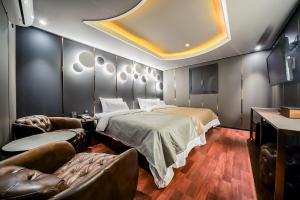 首爾的住宿－THE GRAY HOTEL，一间卧室配有一张床、一张沙发和椅子
