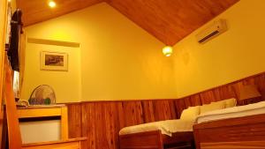 a bedroom with a bed and a yellow wall at Free Beach Resort in Phú Quốc