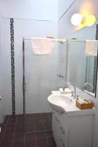 uma casa de banho com um lavatório e um chuveiro em Alpine Resort Motel em Jindabyne