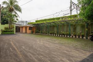 an empty street with a green fence and a building at RedDoorz Plus near Ancol in Jakarta
