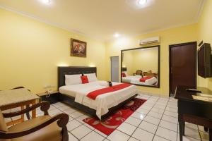 a hotel room with a bed and a mirror at RedDoorz Plus near Ancol in Jakarta
