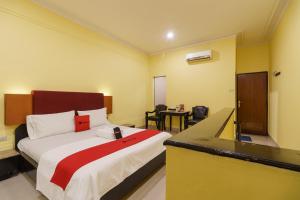 a hotel room with a bed and a desk at RedDoorz Plus near Ancol in Jakarta