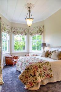 sypialnia z dużym łóżkiem i oknami w obiekcie Villa Walton Bed & Breakfast w mieście Matamata