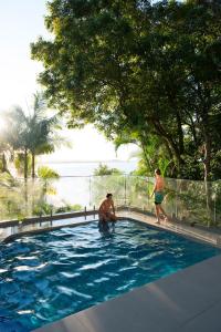 un par de personas en una piscina en Hastings Park: Luxury Penthouse, Private Pool & Views, en Noosa Heads